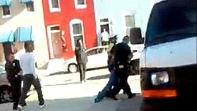 A screenshot from a video showing Baltimore police dragging Freddie Gray into a police vehicle moments before his death.