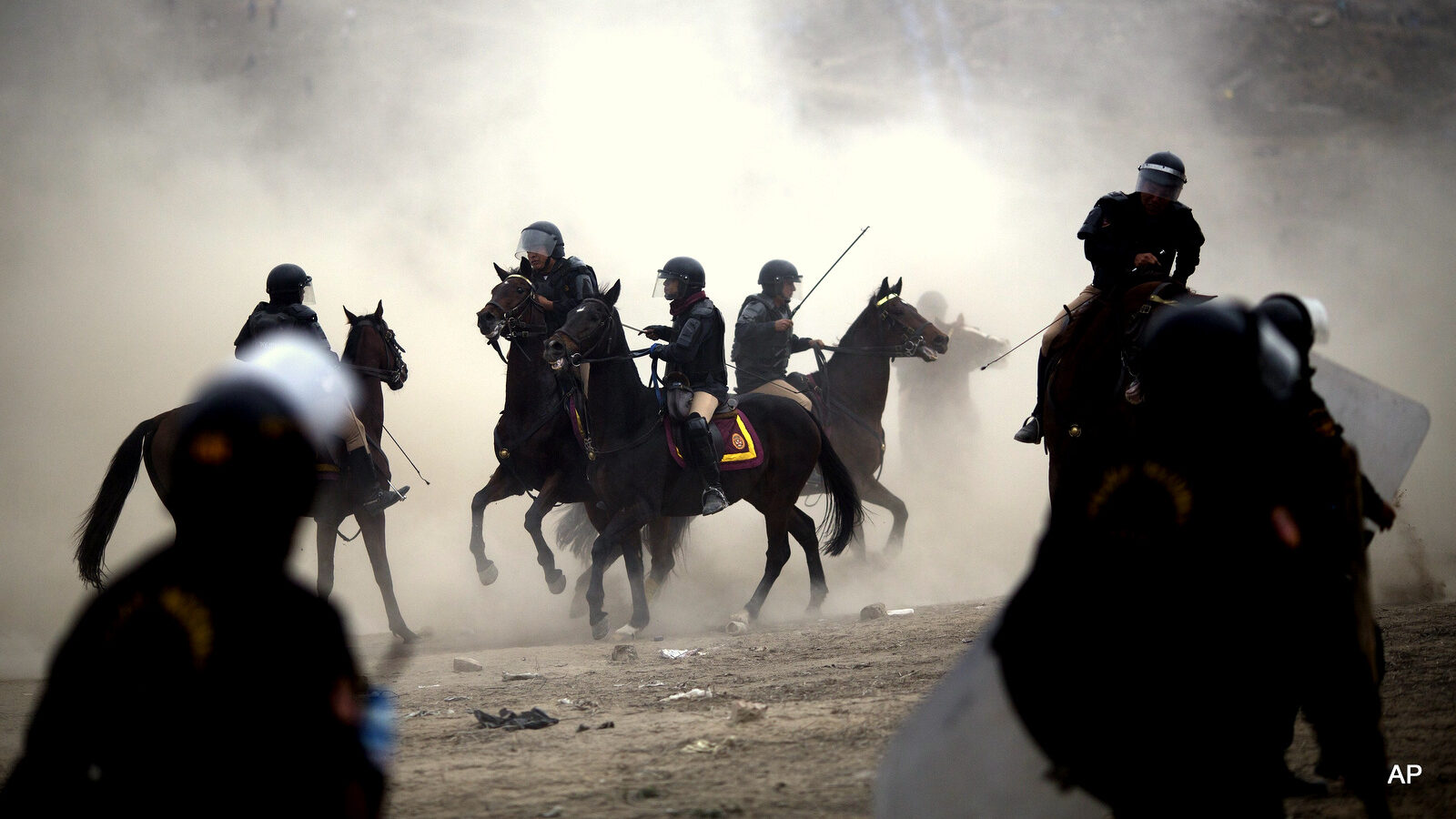 Mounted riot police clash with squatters during a land eviction in Lima Peru, Tuesday, May 19, 2015. On Monday hundreds of people squatted on land that according to the Ministry of Culture is an archaeological site.