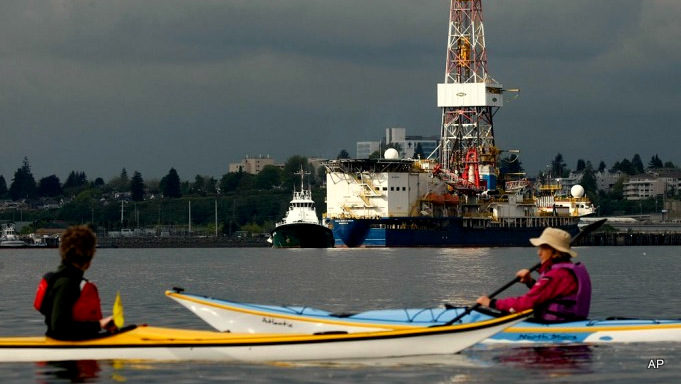 Activists with the "SHELL NO! Flotilla" group watch as the Noble Discoverer oil drilling ship comes in to dock at a Port of Everett, Washington, pier Tuesday evening, May 12, 2015.