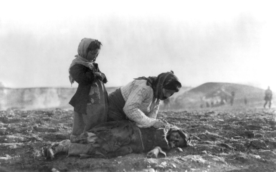 An Armenian woman kneeling beside a dead child in field "within sight of help and safety at Aleppo", an Ottoman city.