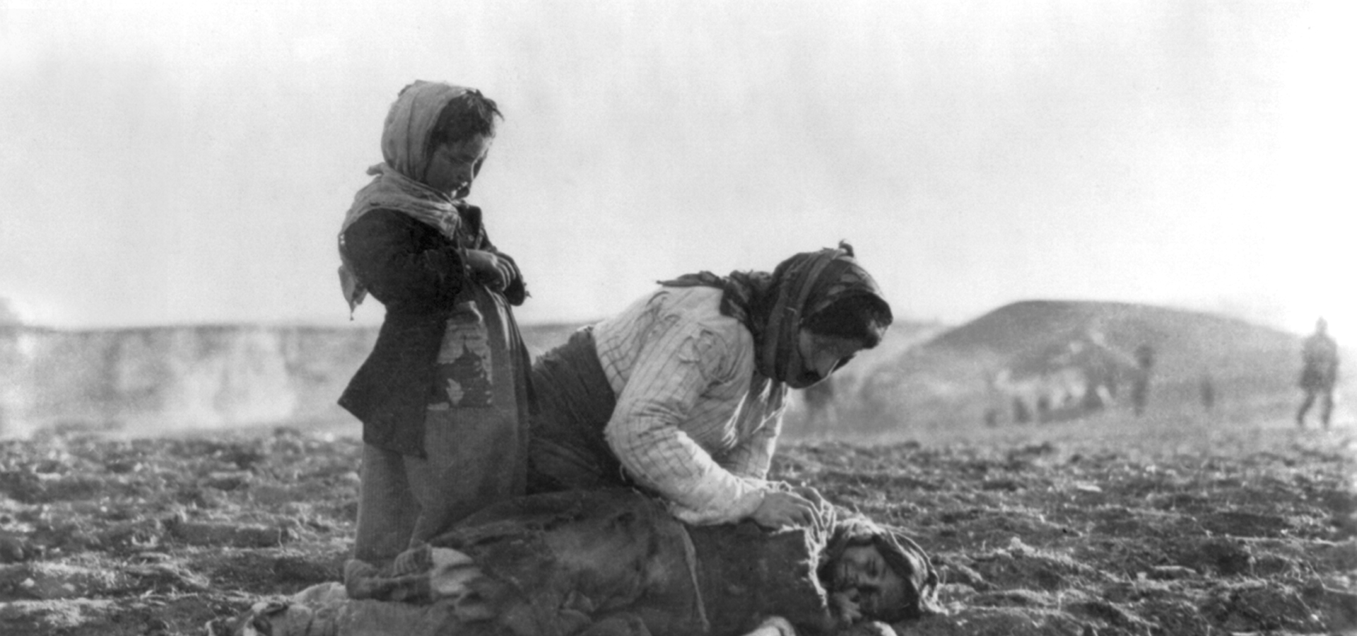 An Armenian woman kneeling beside a dead child in field "within sight of help and safety at Aleppo", an Ottoman city.