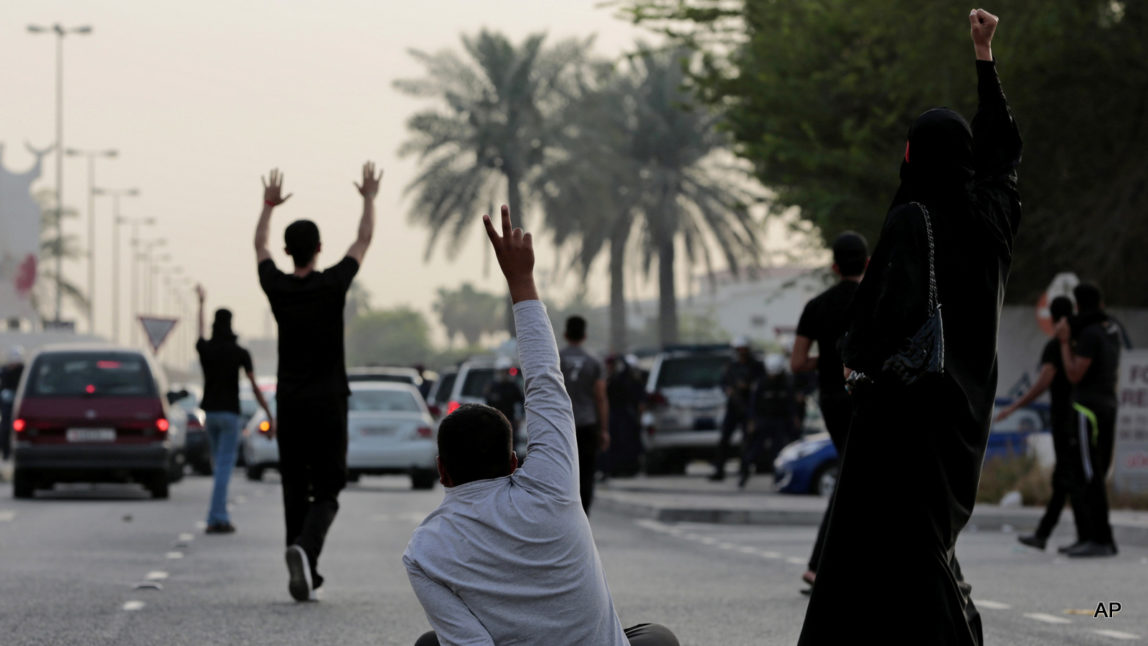 Bahraini Shiite Muslim protesters confront riot police blocking the path of their protest march during a demonstration denouncing a suicide bombing at a Shiite mosque in Saudi Arabia, in Daih, Bahrain, Saturday, May 23, 2015. The unauthorized protest was dispersed by riot police firing tear gas and birdshot. The Islamic State group claimed responsibility for the Saudi mosque bombing that killed and wounded many people.