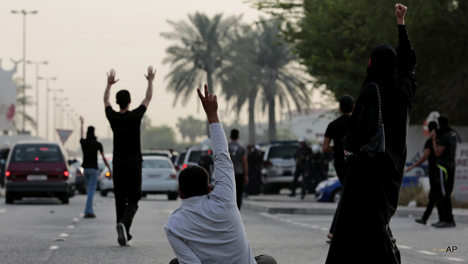 Bahraini Shiite Muslim protesters confront riot police blocking the path of their protest march during a demonstration denouncing a suicide bombing at a Shiite mosque in Saudi Arabia, in Daih, Bahrain, Saturday, May 23, 2015. The unauthorized protest was dispersed by riot police firing tear gas and birdshot. The Islamic State group claimed responsibility for the Saudi mosque bombing that killed and wounded many people. 