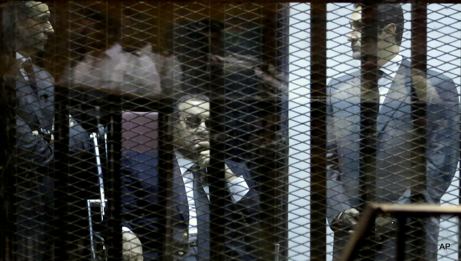 Former Egyptian President Hosni Mubarak, seated, and his two sons Gamal Mubarak, left, and Alaa Mubarak, right, attend the verdict of the corruption case dubbed by the Egyptian media as the "presidential palaces" affair concerning charges that Mubarak and his two sons embezzled millions of dollars' worth of state funds over the course of a decade in a courtroom in Cairo, Egypt, Saturday, May 9, 2015. Egypt's deposed leader Hosni Mubarak and his two sons were sentenced Saturday to three years in prison and a fine in a retrial on corruption charges they faced earlier. It wasn't immediately clear whether it will include time he's already served since his country's 2011 revolt.