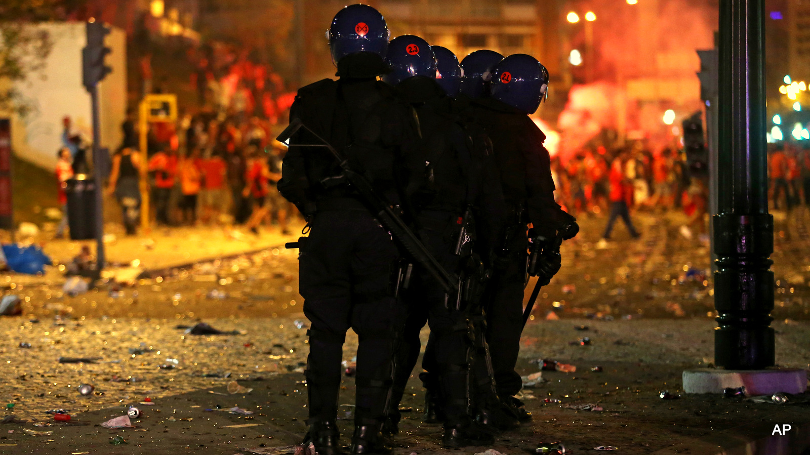 Portuguese anti-riot policemen in full gear stand guard during clashes with Benfica supporters after Benfica won the Portuguese league championship, at the Marques Pombal square, in Lisbon, Sunday, May 17, 2015. Benfica clinched its 34th league title after a 0-0 draw against Vitoria Guimaraes with one round left to play.