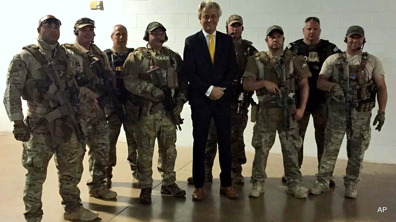 In this photo provided on Monday, May 4, 2015 by Geert Wilders, Dutch lawmaker Geert Wilders, leader of the anti-Islam Freedom Party, center, poses for a photograph with police officers he hired in advance of a provocative contest for cartoon depictions of Prophet Muhammad in Garland, Texas.