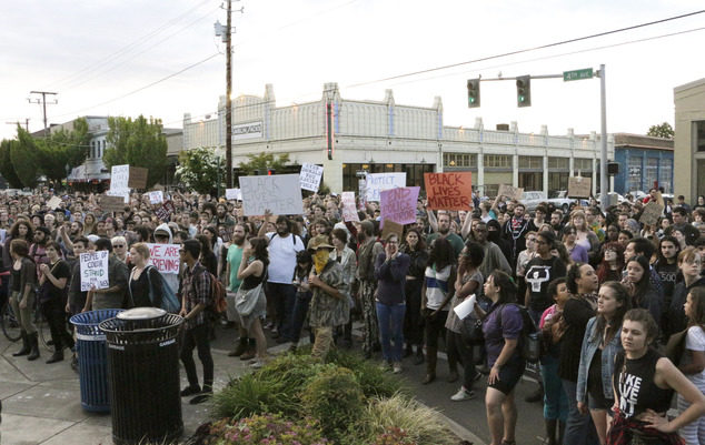 Hundreds of people protesting a police shooting gather outside of City Hall in Olympia, Wash., on Thursday, May 21, 2015. Police say that two stepbrothers suspected of trying to steal beer from a grocery store were unarmed when they were shot by a police officer who confronted them. (AP Photo/Rachel La Corte)