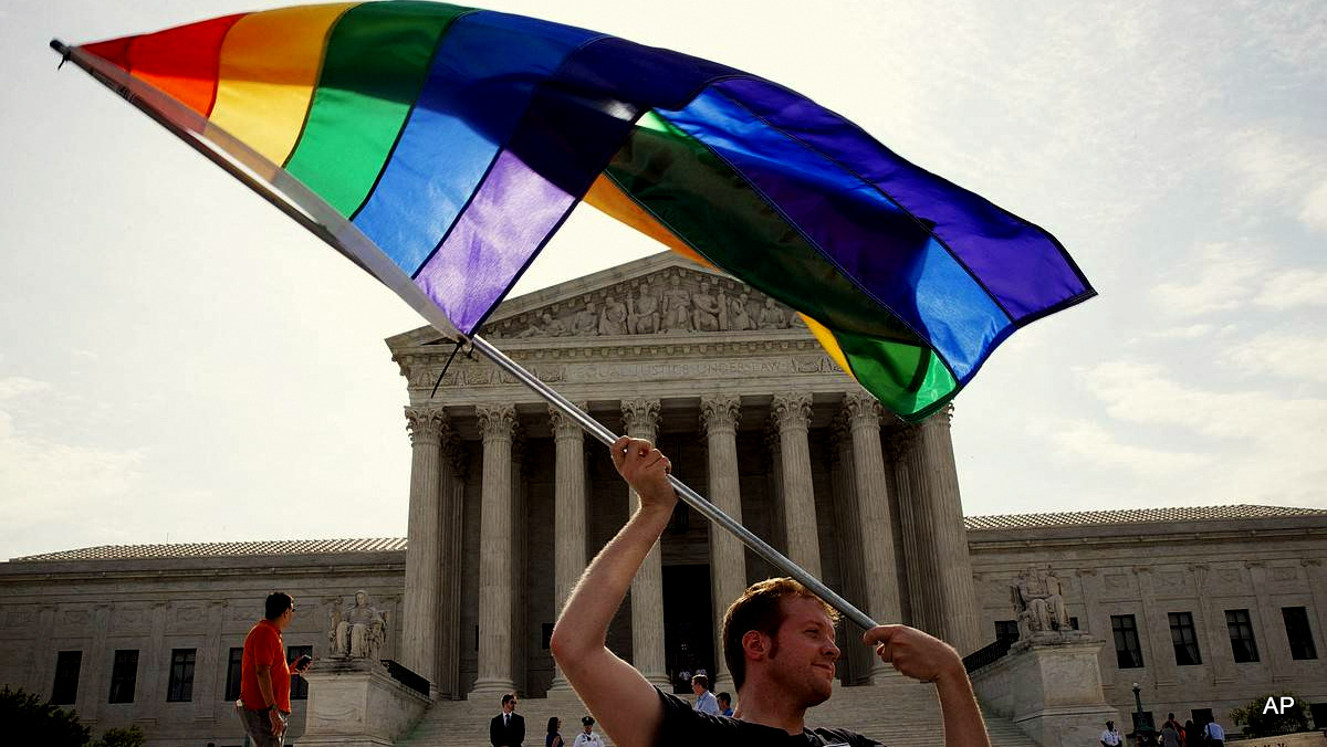 John Becker, 30, of Silver Spring, Md., waves a rainbow flag in support of gay marriage outside of the Supreme Cour