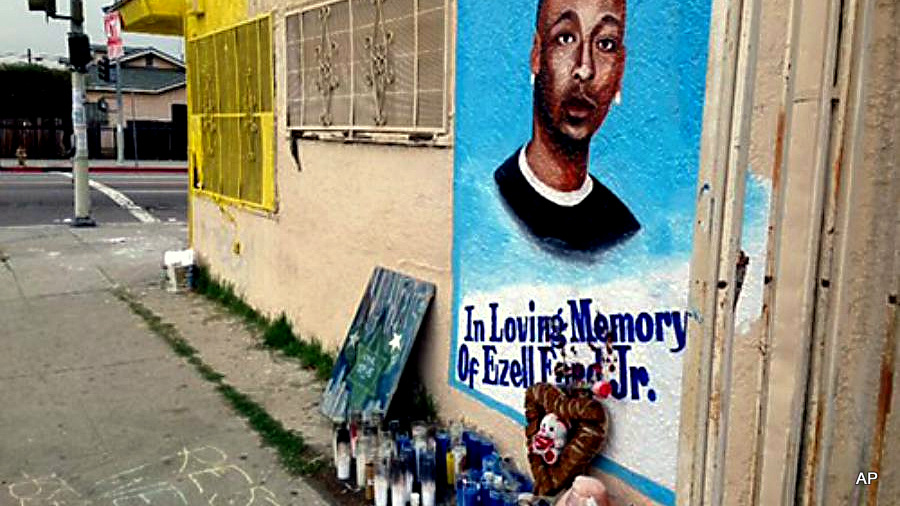A street side memorial in with a painted portrait of Ezell Ford