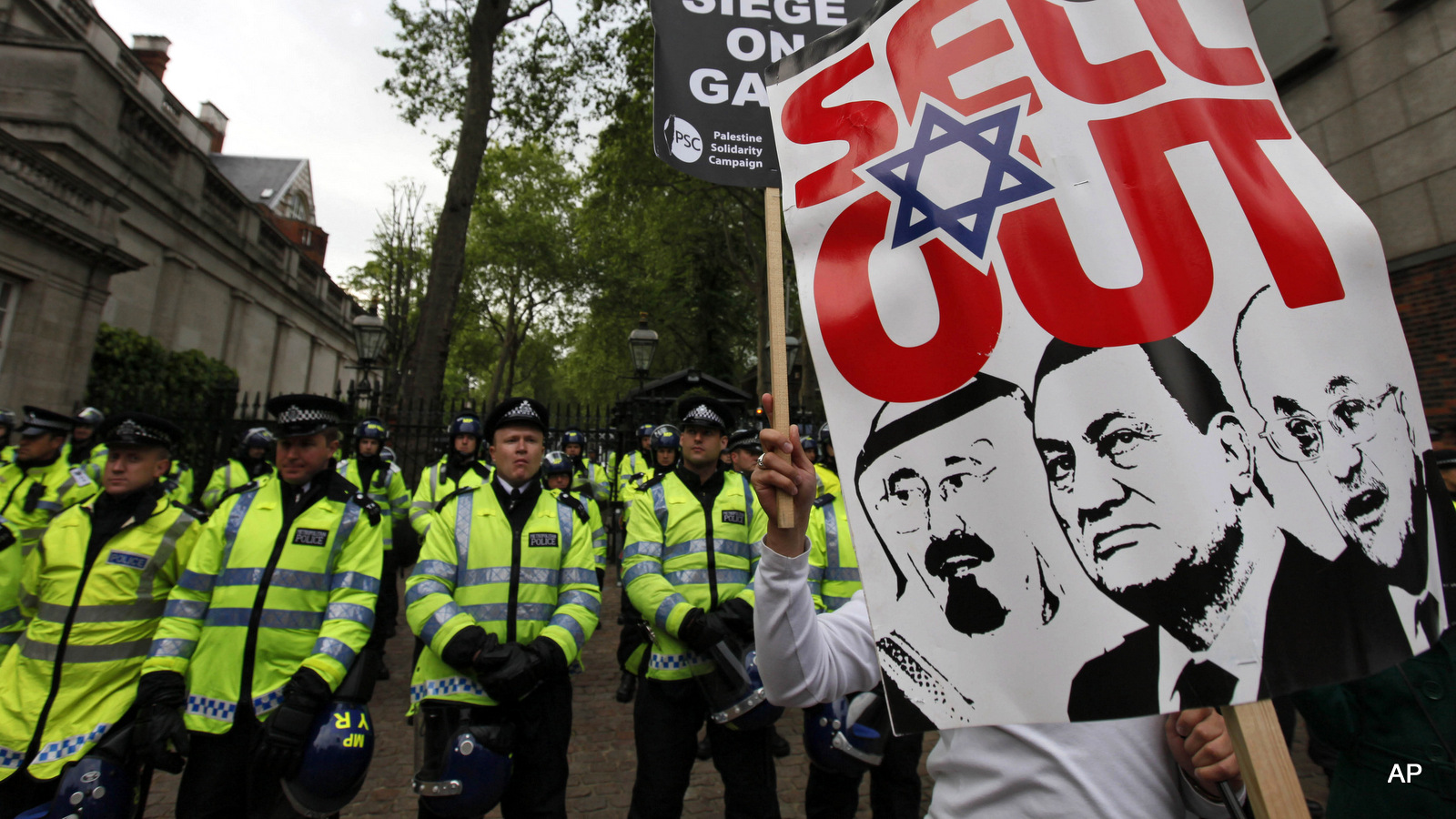 a pro-Palestinian supporter, holding a placard depicting Arab leaders