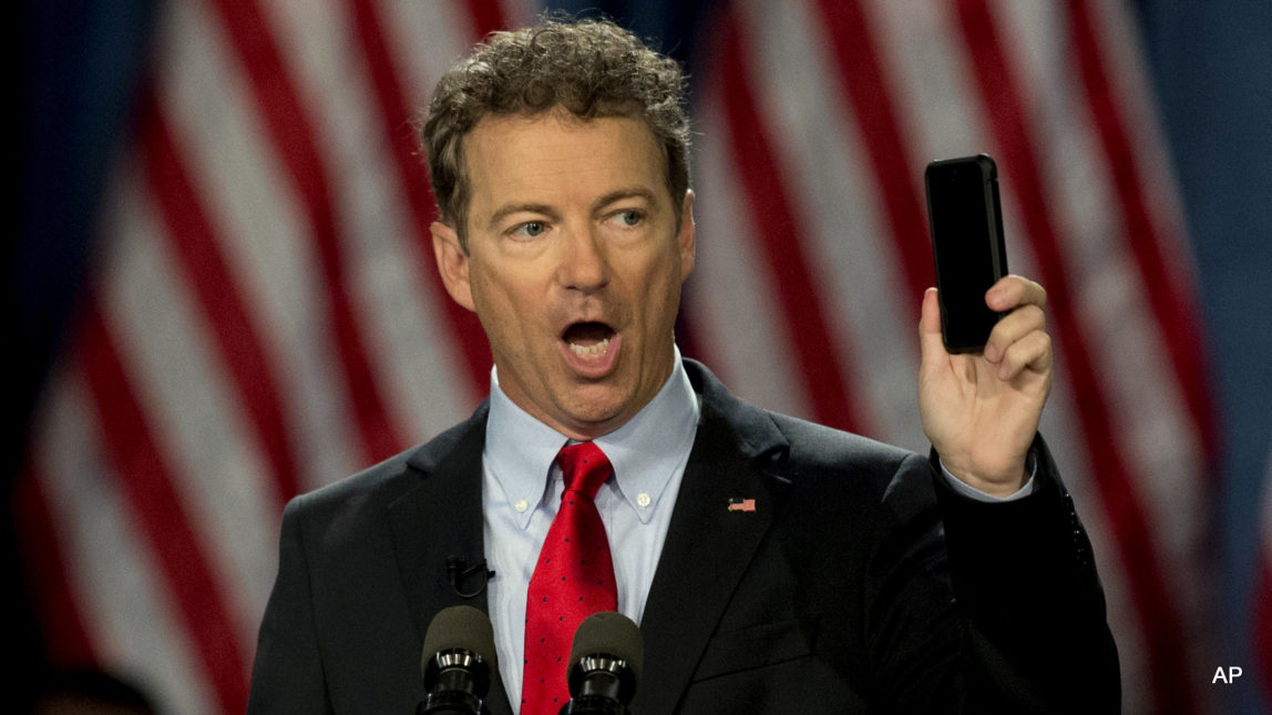 Sen. Rand Paul, R-Ky. holds up his cell phone as he speaks before announcing the start of his presidential campaign, in Louisville, Ky. Key Patriot Act anti-terror provisions, including bulk collection of Americans’ phone records, expire at midnight unless senators come up with an 11th hour deal in an extraordinary Sunday afternoon session.