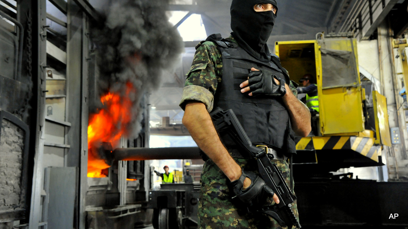 An Uzbekistan National Security Service officer stands guard, as drugs are burnt behind him