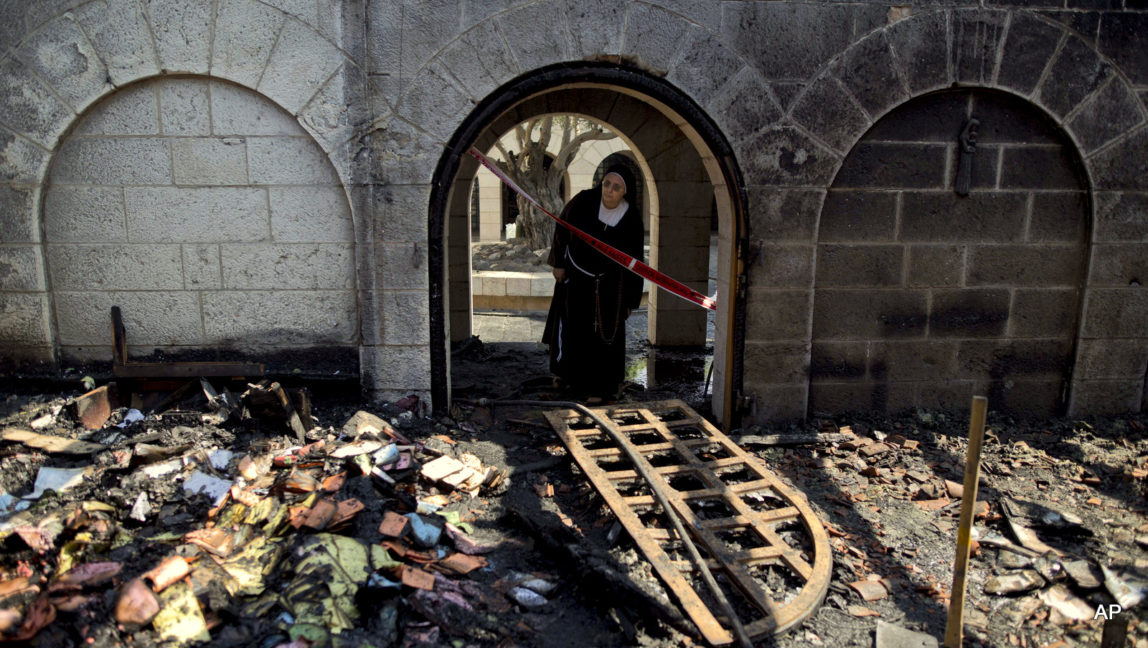 A nun looks at a heavily damaged Church of Multiplication after a fire broke out overnight near the Sea of Galilee in Tabgha, Israel