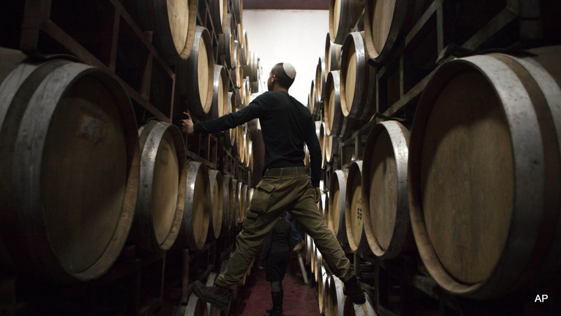 an Israeli worker inspects barrels in a winery in the West Bank settlement of Psagot