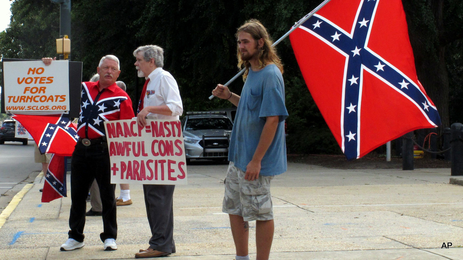William Cheek, left, Nelson Waller, center, and Jim Collins, right, protest proposals to remove the Confederate flag from the grounds of the South Carolina Statehouse