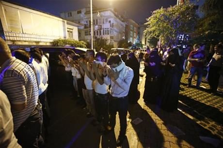 Uighurs living in Turkey and Turkish supporters offer their Muslim prayers outside the Thai consulate in Istanbul, early Thursday, July 9, 2015. A group of protesters stormed the consulate overnight, smashing windows and breaking in to the offices, where they destroyed pictures and furniture and hurled files out into the yard, to denounce Thailand’s decision to deport 109 ethnic Uighur migrants back to China. Turkey has cultural ties to the minority Muslim Uighurs and pro-Uighur groups fear the 109 face persecution by the Chinese government. (AP Photo)