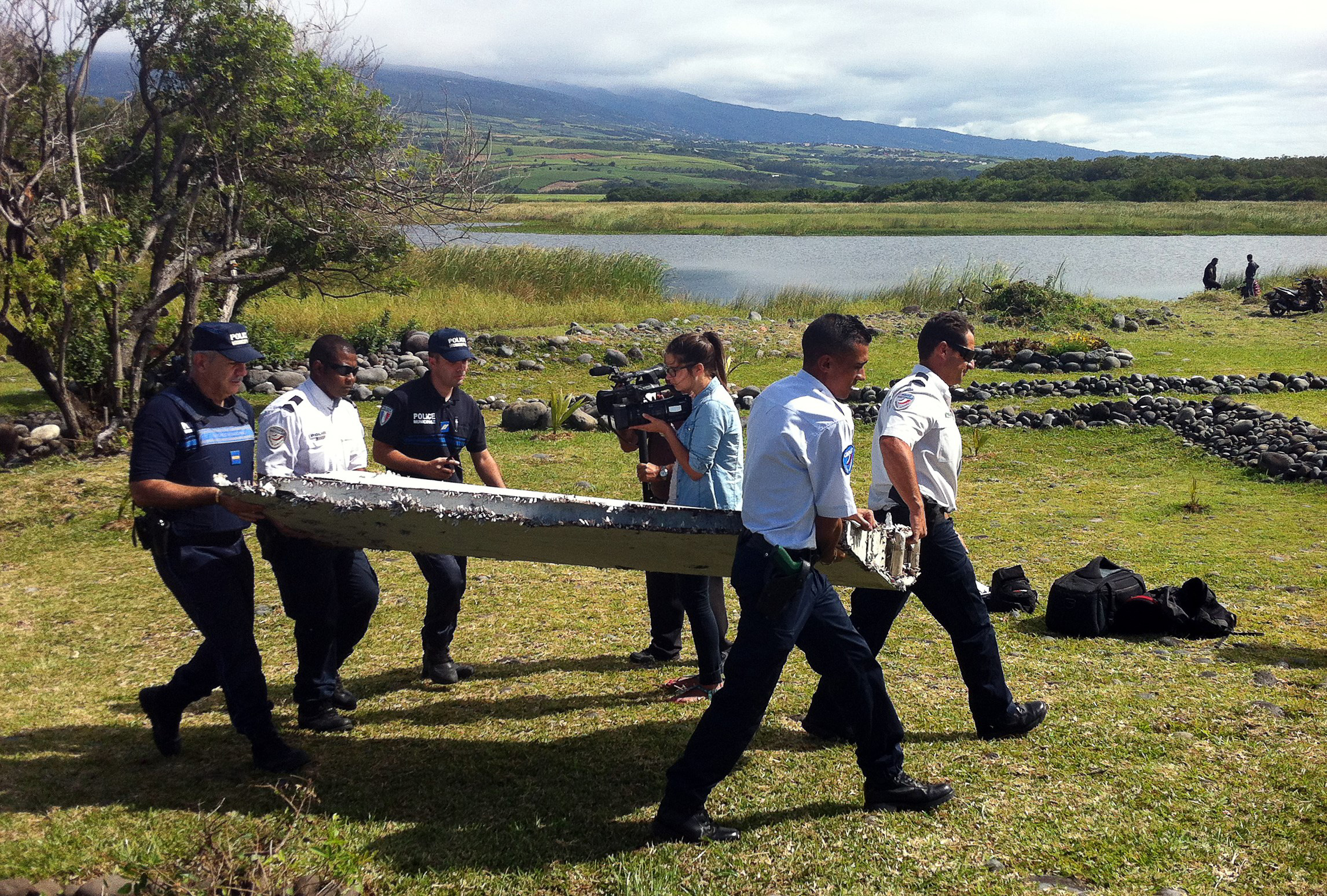 Police carry a piece of debris from an unidentified aircraft found in the coastal area of Saint-Andre de la Reunion, in the east of the French Indian Ocean island of La Reunion, on July 29, 2015.  The two-metre-long debris, which appears to be a piece of a wing, was found by employees of an association cleaning the area and handed over to the air transport brigade of the French gendarmerie (BGTA), who have opened an investigation. An air safety expert did not exclude it could be a part of the Malaysia Airlines flight MH370, which went missing in the Indian Ocean on March 8, 2014. AFP PHOTO / YANNICK PITOU        (Photo credit should read YANNICK PITOU/AFP/Getty Images)