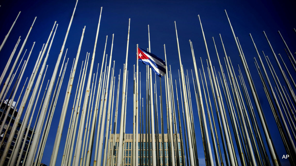 A Cuban flag flies among empty flag polls near the U.S. Interests Section building
