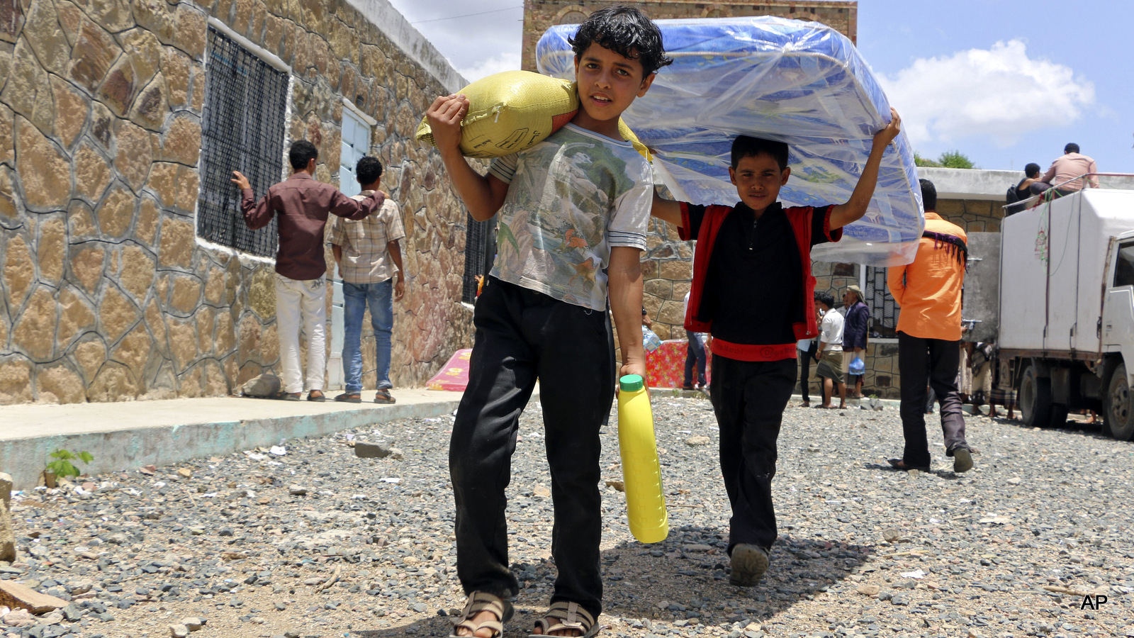 Boys carry relief supplies to their families who fled fighting in the southern city of Aden, during a food distribution effort by Yemeni volunteers, in Taiz, Yemen.