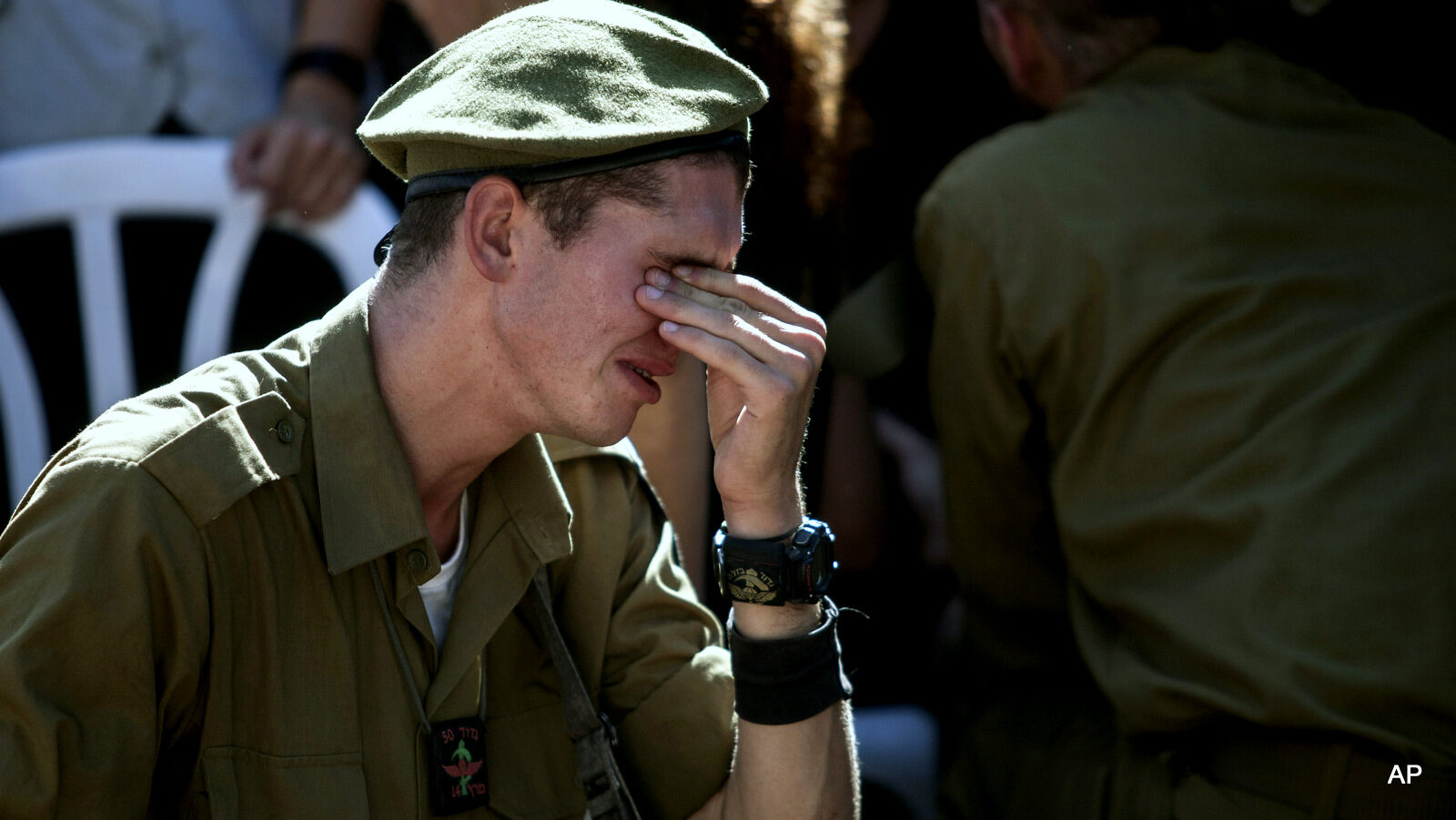 An Israeli soldier mourns over the grave of a soldier killed during Israeli last assault on the Gaza Strip, during his funeral at the military cemetery in Rehovot, Israel, Friday, July 25, 2014.