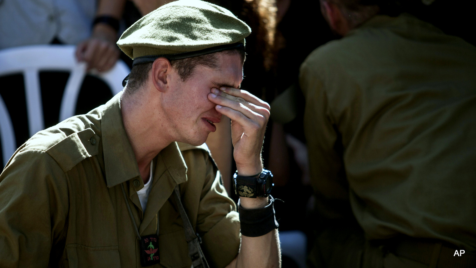 An Israeli soldier mourns over the grave of a soldier killed during Israeli last assault on the Gaza Strip, during his funeral at the military cemetery in Rehovot, Israel, Friday, July 25, 2014. 