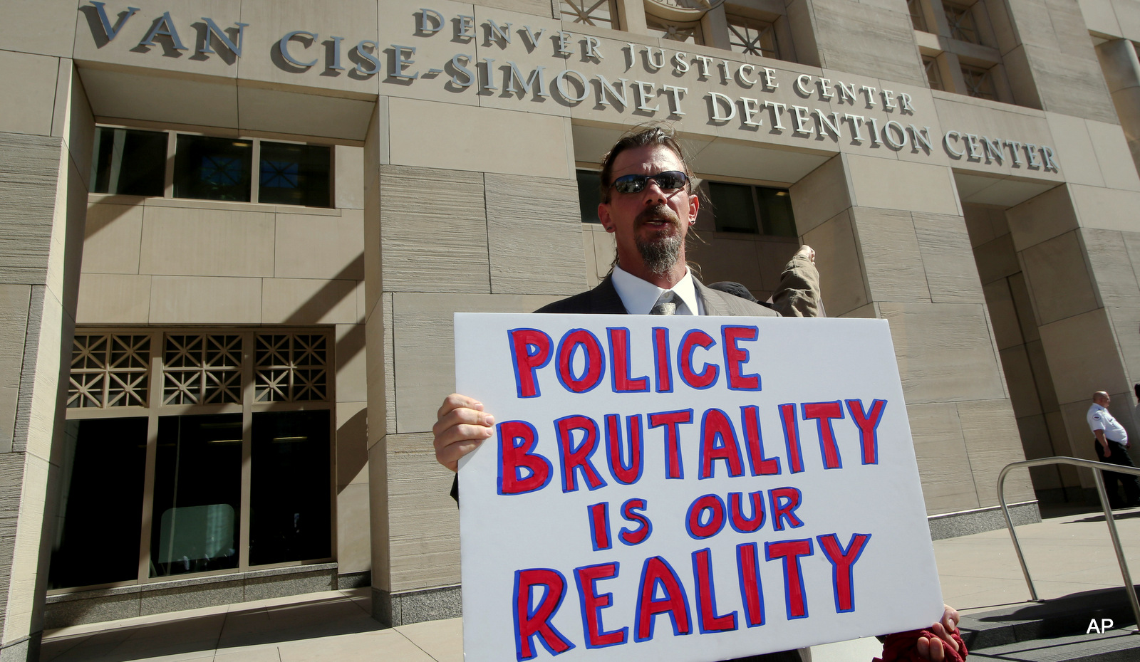 A protester Michael J. Moore holds a sign against the city jail in Denver, CO.