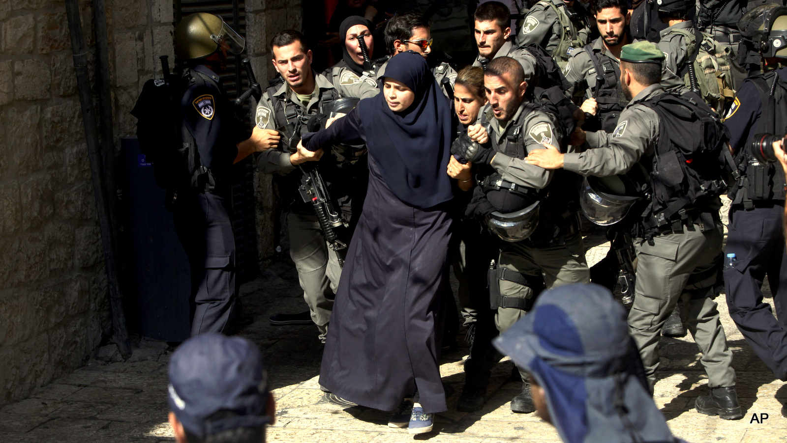 Israeli border police officers scuffle with Palestinian women in the Old City of Jerusalem on Sunday, July 26, 2015. Israeli police said they entered the al-Aqsa Mosque, the second-most holy site for Muslims, to "prevent Arab youths from attacking visiting Jews"