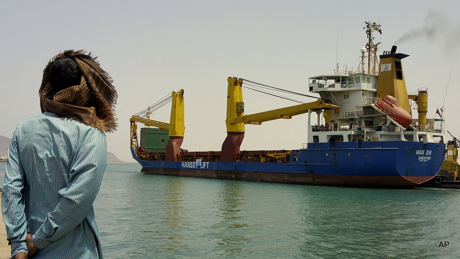 A Yemeni man looks at a World Food Program ship at the port of Aden, Yemen