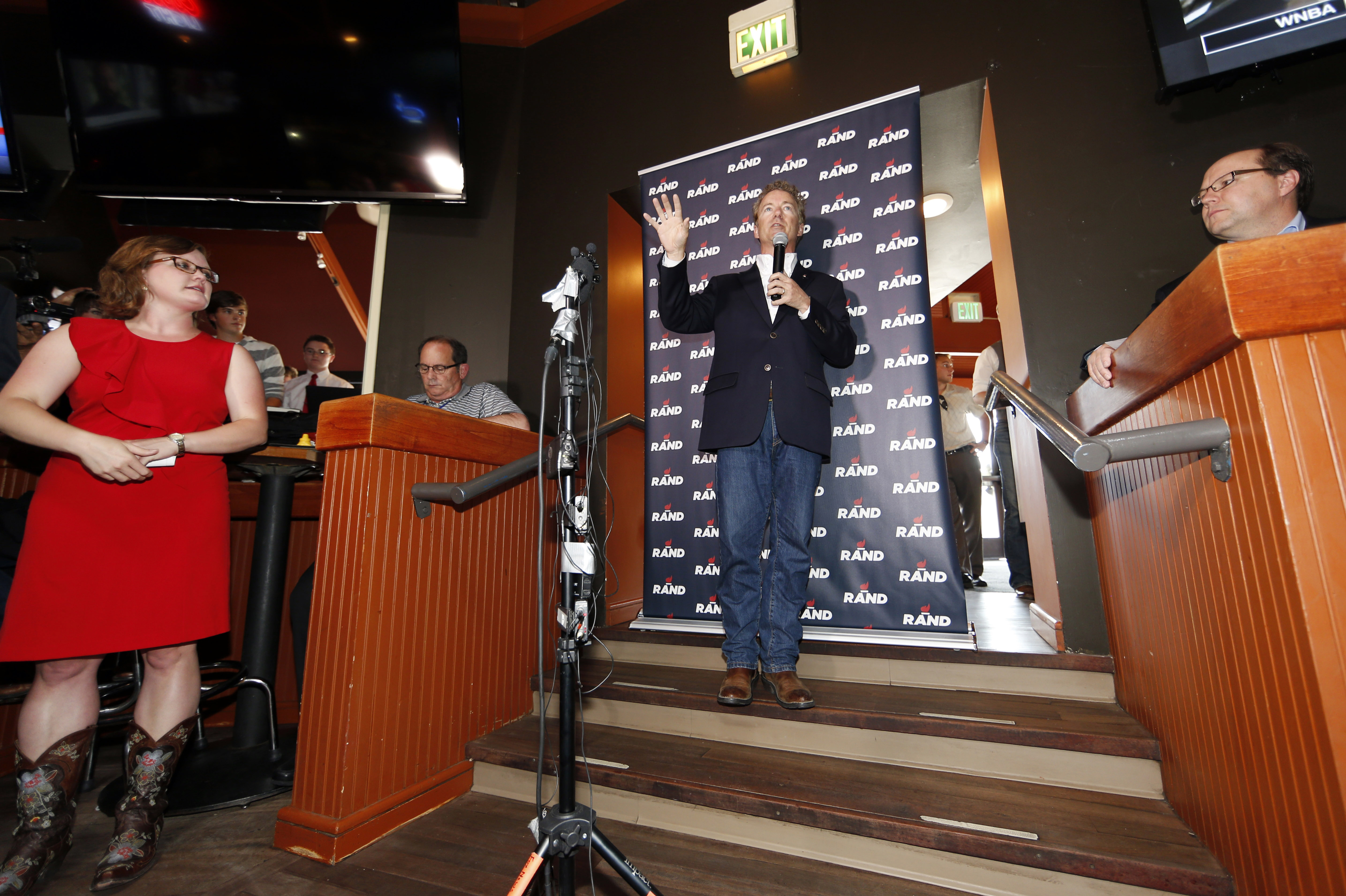 Republican presidential hopeful Sen. Rand Paul, center, speaks during a campaign stop at a sports bar in the tony Cherry Creek area