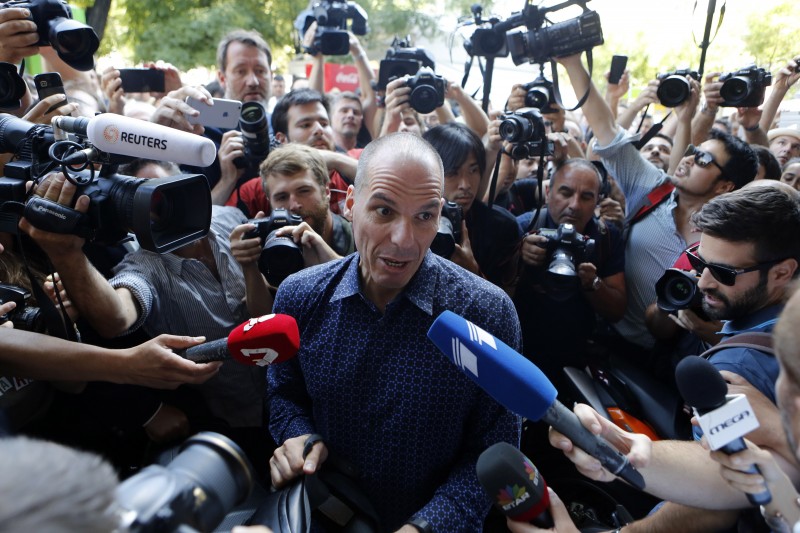Outgoing Greek Finance Minister Yanis Varoufakis is surrounded by media as he tries to leave on his motorcycle, after his resignation in Athens, Monday, July 6, 2015. Greece and its membership in Europe's joint currency faced an uncertain future Monday, with the country under pressure to reach a bailout deal with creditors as soon as possible after Greeks resoundingly rejected the notion of more austerity in exchange for aid. (AP Photo/Petros Karadjias)