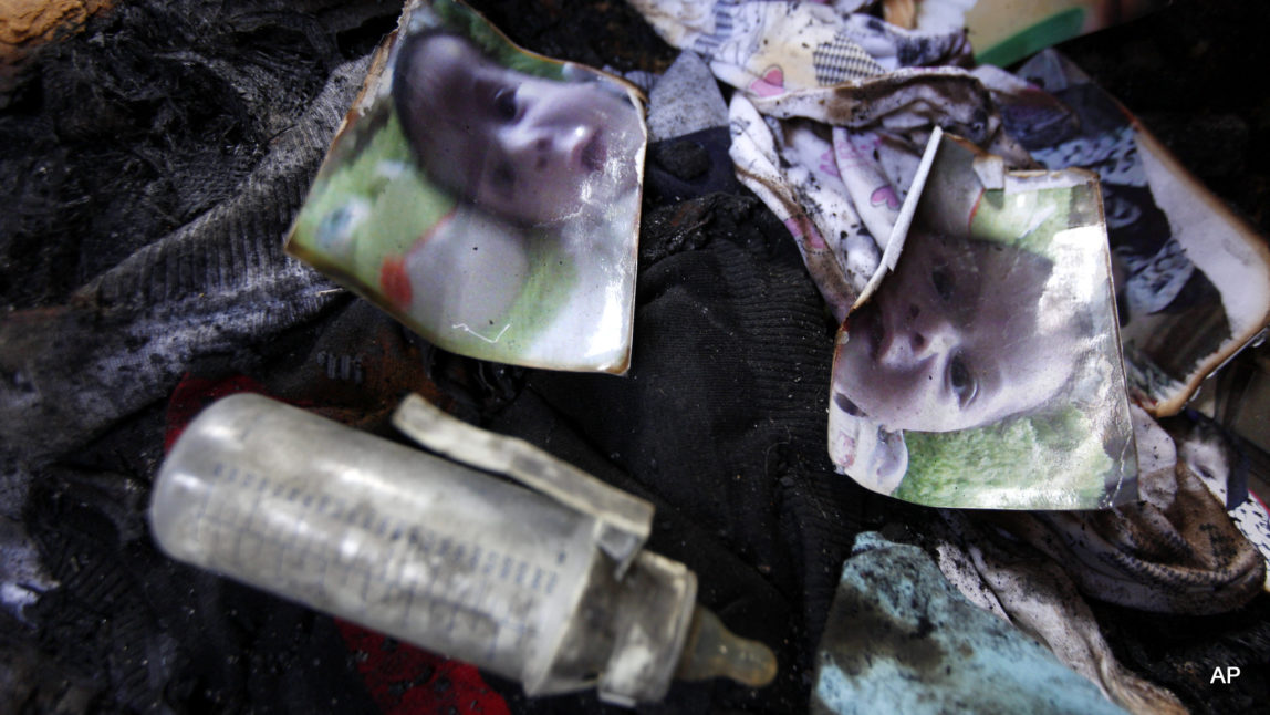 Photos of a one-and-a-half year old boy, Ali Dawabsheh, lie in a house that had been torched in a suspected attack by Jewish settlers in Duma village near the West Bank city of Nablus, Friday, July 31, 2015. The boy died in the fire, his four-year-old brother and parents were wounded, according to a Palestinian official from the Nablus area.