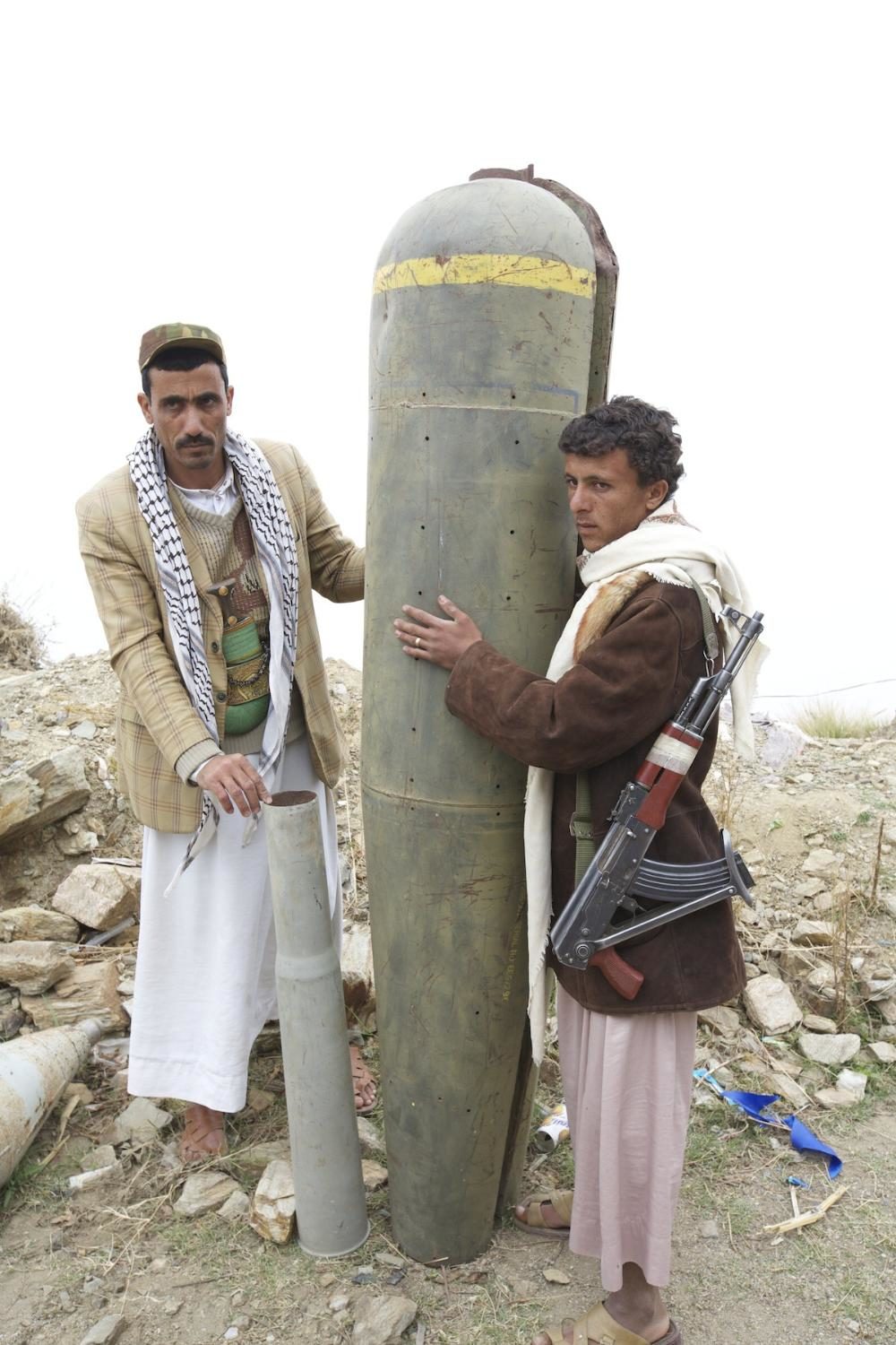 Houthi rebels pose with a US-made cluster bomb shell in northern Yemen.