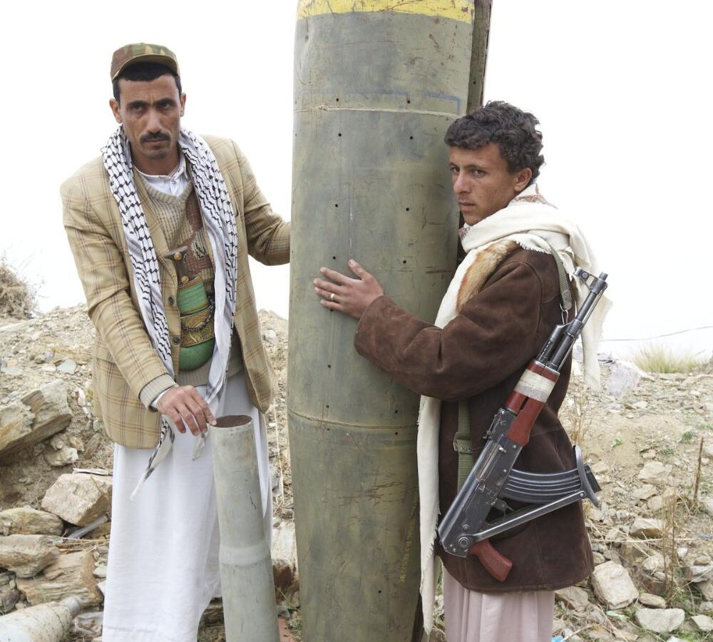 Houthi rebels pose with a US-made cluster bomb shell in northern Yemen.