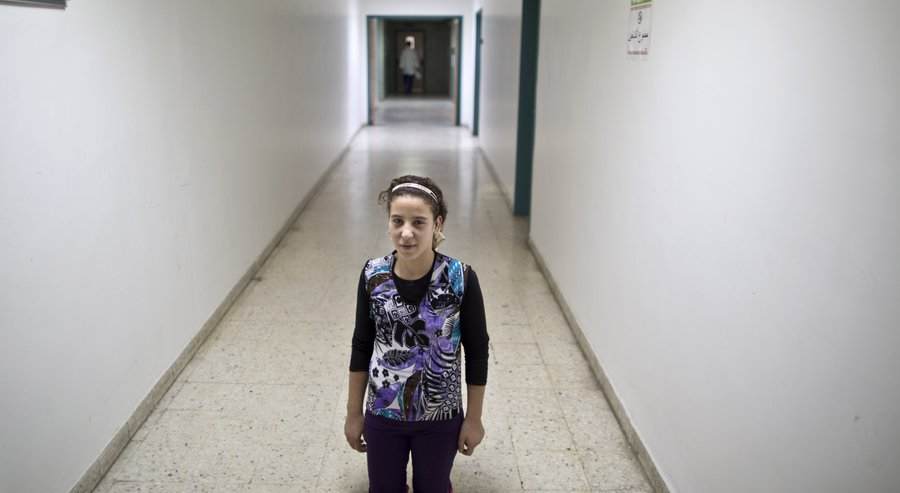 In this Tuesday, Aug. 11, 2015 photo, Syrian girl Salam Rashid, 14, who lost both of her legs below the knee in 2012 in a tank shell attack, poses for a picture at the MSF Hospital for Specialized Reconstructive Surgery in Amman, Jordan. The international charity Médecins Sans Frontières (Doctors Without Borders) officially inaugurates in Amman next month its new reconstructive surgery hospital for war victims, which it says is unique in the region. (AP Photo/Muhammed Muheisen) The Associated Press