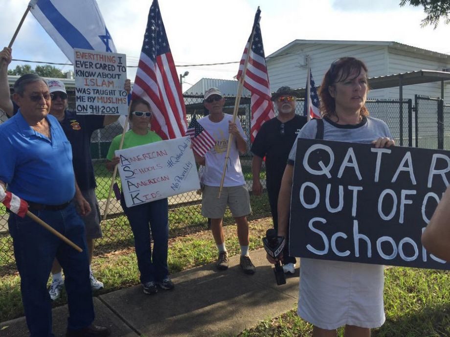 Protesters outside the Houston ISD's Arabic Immersion Magnet School carry signs reading "Qatar out of my school" and "Everything I ever cared to know about Islam was taught to me by Muslims on 9-11-2001" on the first day of school, Monday, Aug. 24, 2015. |