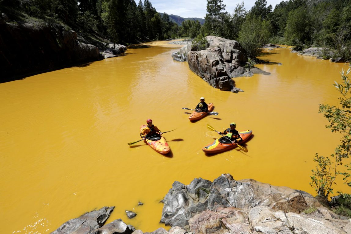 People kayak in the Animas River near Durango, Colo., in water colored from a mine waste spill