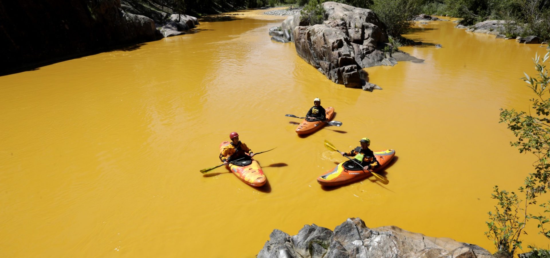 People kayak in the Animas River near Durango, Colo., in water colored from a mine waste spill