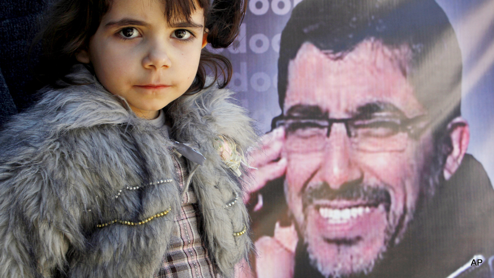 MariaAbu Sisi , pauses in front of a portrait of her father Dirar Abu Sisi