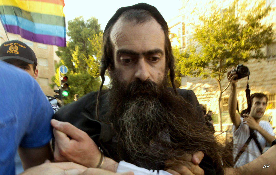 Ultra Orthodox Jew Yishai Schlissel is detained by plain-clothes police officers after he stabbed people during a gay pride parade in Jerusalem on Thursday, July 30, 2015. Schlisse was recently released from prison after serving a term for stabbing several people at a gay pride parade in 2005, a police spokeswoman said.