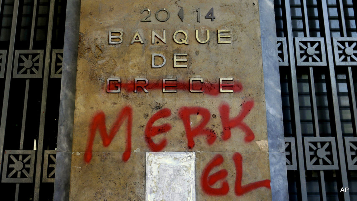 Red spray paint covers a French-language Bank of Greece sign to read 'Bank of Merkel' in reference to German Chancellor Angela Merkel in Athens, Monday, July 6, 2015.