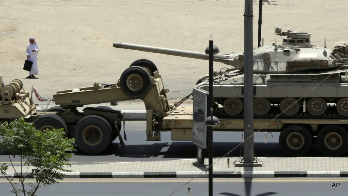 A Saudi man looks at an army tank being transported, in the city of Najran, Saudi Arabia, near the border with Yemen, Thursday, April 23, 2015.