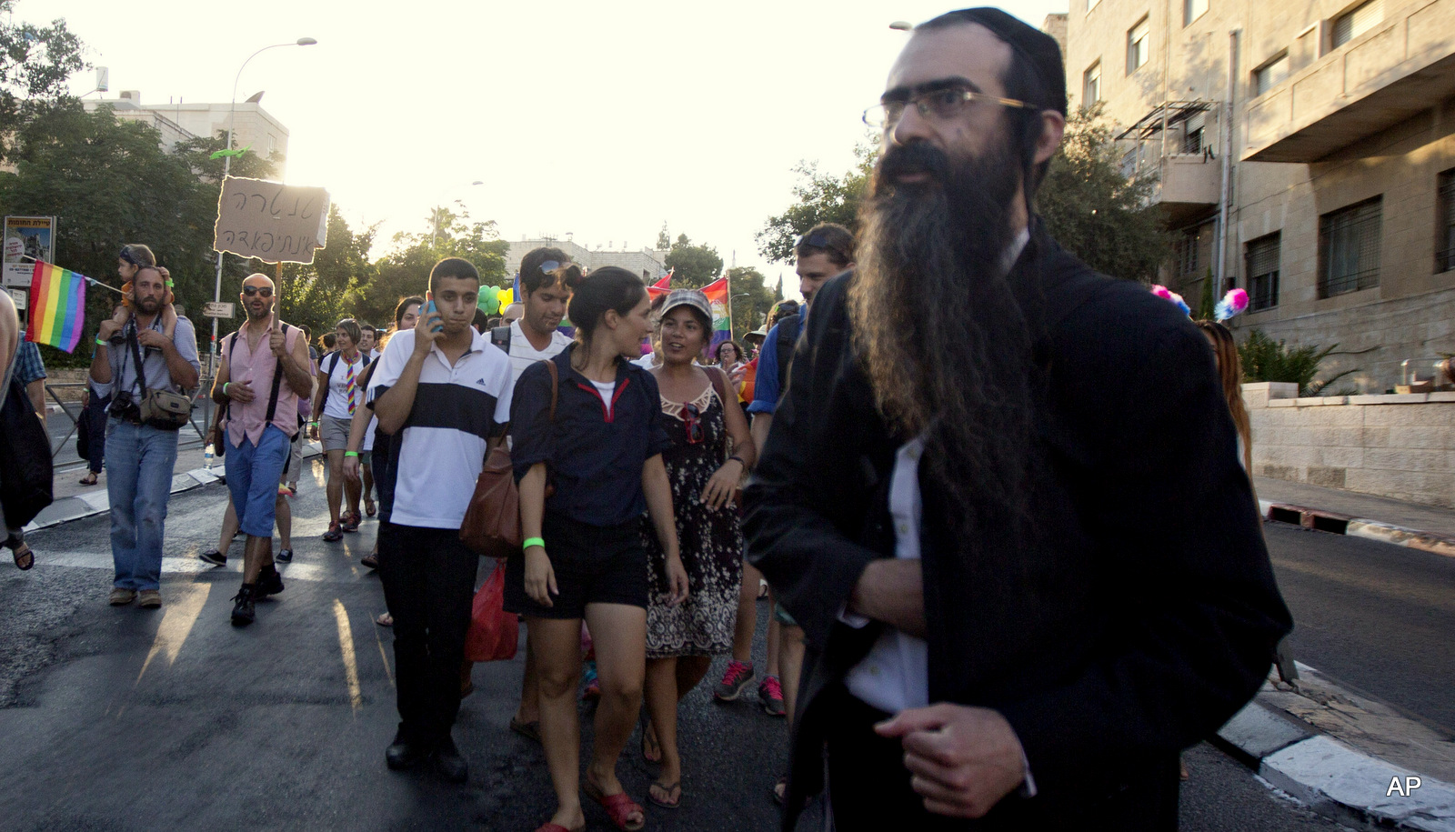 Ultra-Orthodox Jew Yishai Schlissel walks through a Gay Pride parade and is just about to pull a knife from under his coat and start stabbing people in Jerusalem, Thursday, July 30, 2015. Schlissel was recently released from prison after serving a term for stabbing several people at a gay pride parade in 2005, a police spokeswoman said.
