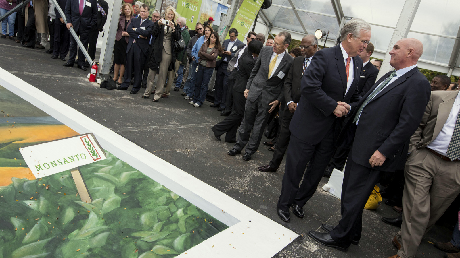 Hugh Grant, right, Monsanto chairman and chief executive officer, speaks with Mo. Gov. Jay Nixon next to a 3D agricultural chalk art piece at Monsanto's Chesterfield Village Research Center expansion groundbreaking on Tuesday, Oct. 22, 2013 in Chesterfield, Mo. The event commemorated the $400 million expansion which is expected to create 675 new jobs in St. Louis over the next three years. (Whitney Curtis / AP Images for Monsanto Co.)