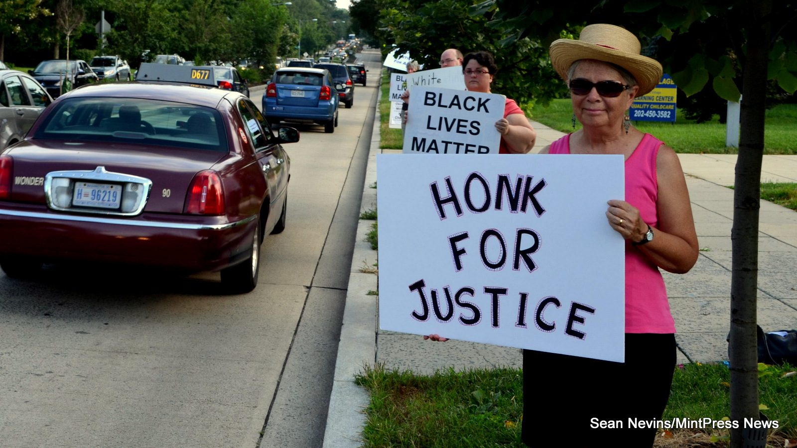 Beth, Danna, Andrew, and others stand on 16th Street NW in front of the Washington Ethical Society in Washington DC on July 30 in remembrance of Samuel Shields, who was killed by prison guards at Prince George’s County Detention Center in Upper Marlboro, Maryland on June 17, 2014. 