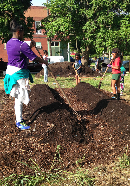 Young people prepare garden beds at the Hamilton Heights community garden.