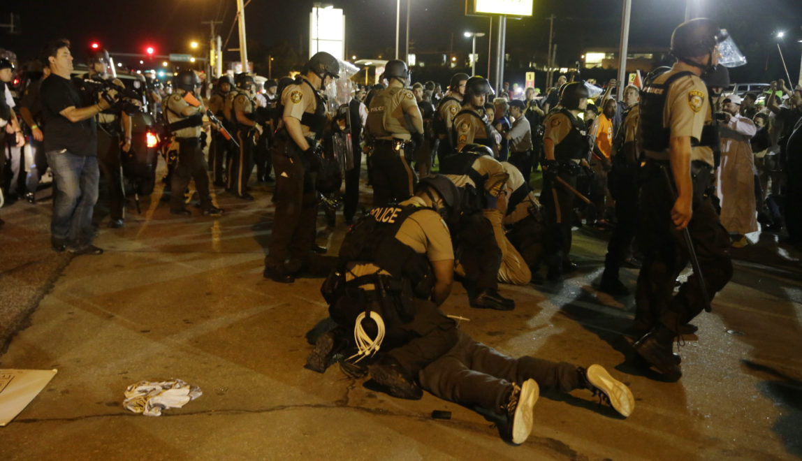 St. Louis County Police arrest people along West Florissant Avenue, Monday, Aug. 10, 2015, in Ferguson, Mo. Ferguson was a community on edge again Monday, a day after a protest marking the anniversary of Michael Brown's death was punctuated with gunshots.