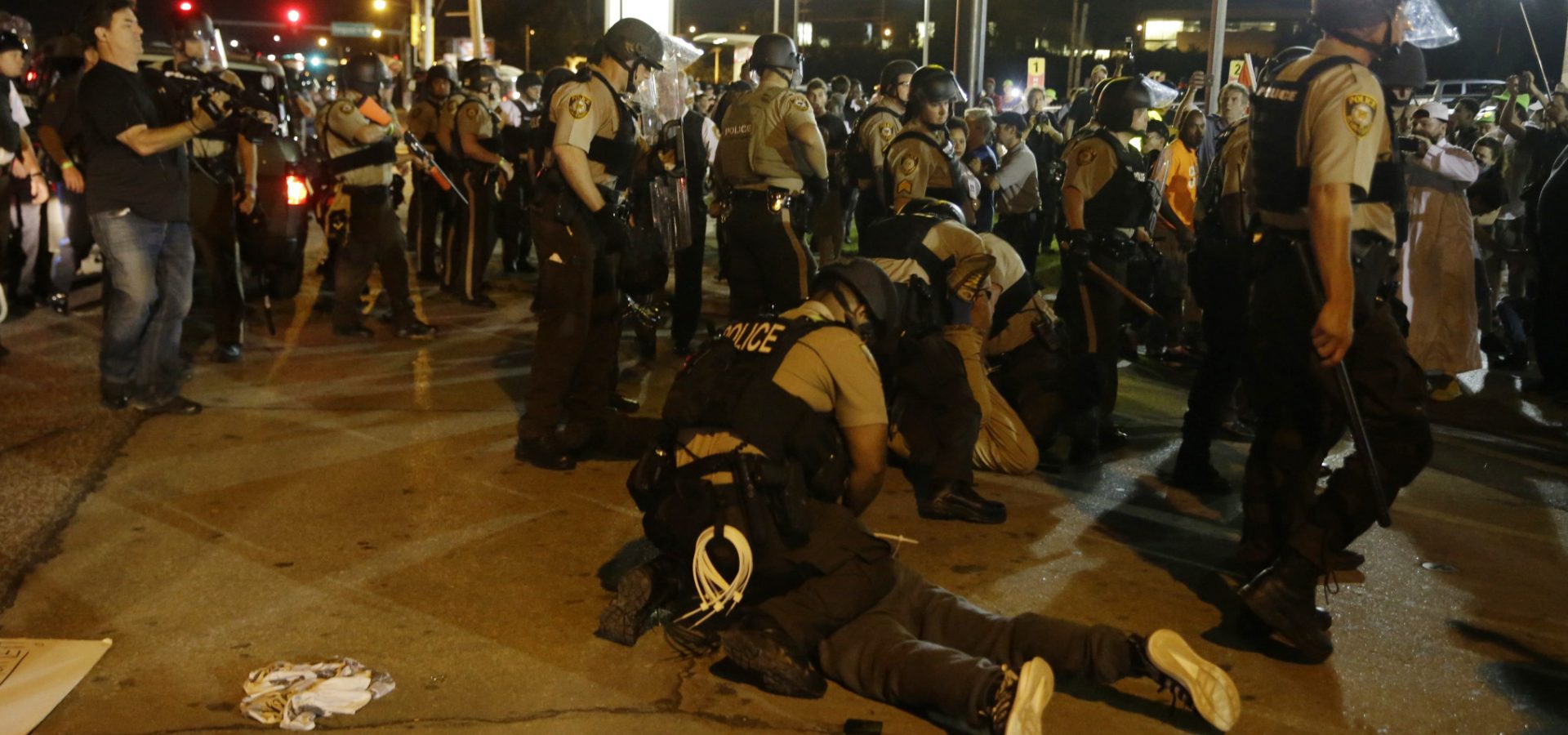 St. Louis County Police arrest people along West Florissant Avenue, Monday, Aug. 10, 2015, in Ferguson, Mo. Ferguson was a community on edge again Monday, a day after a protest marking the anniversary of Michael Brown's death was punctuated with gunshots.