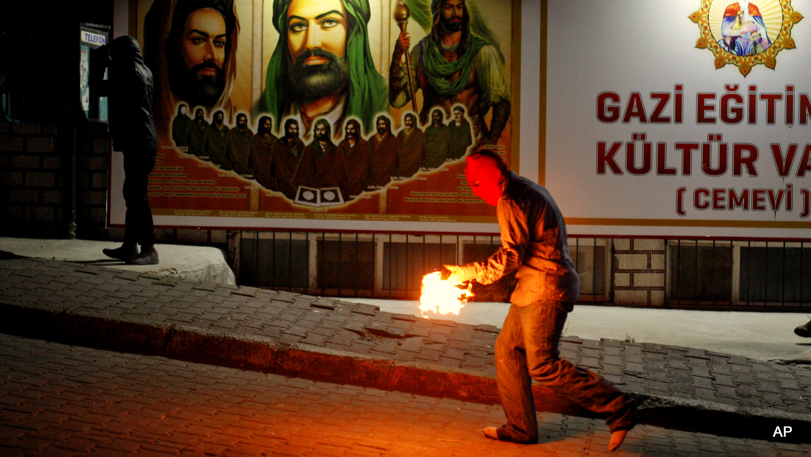 A left-wing protester prepares to hurl a petrol bomb in the direction of Turkish police