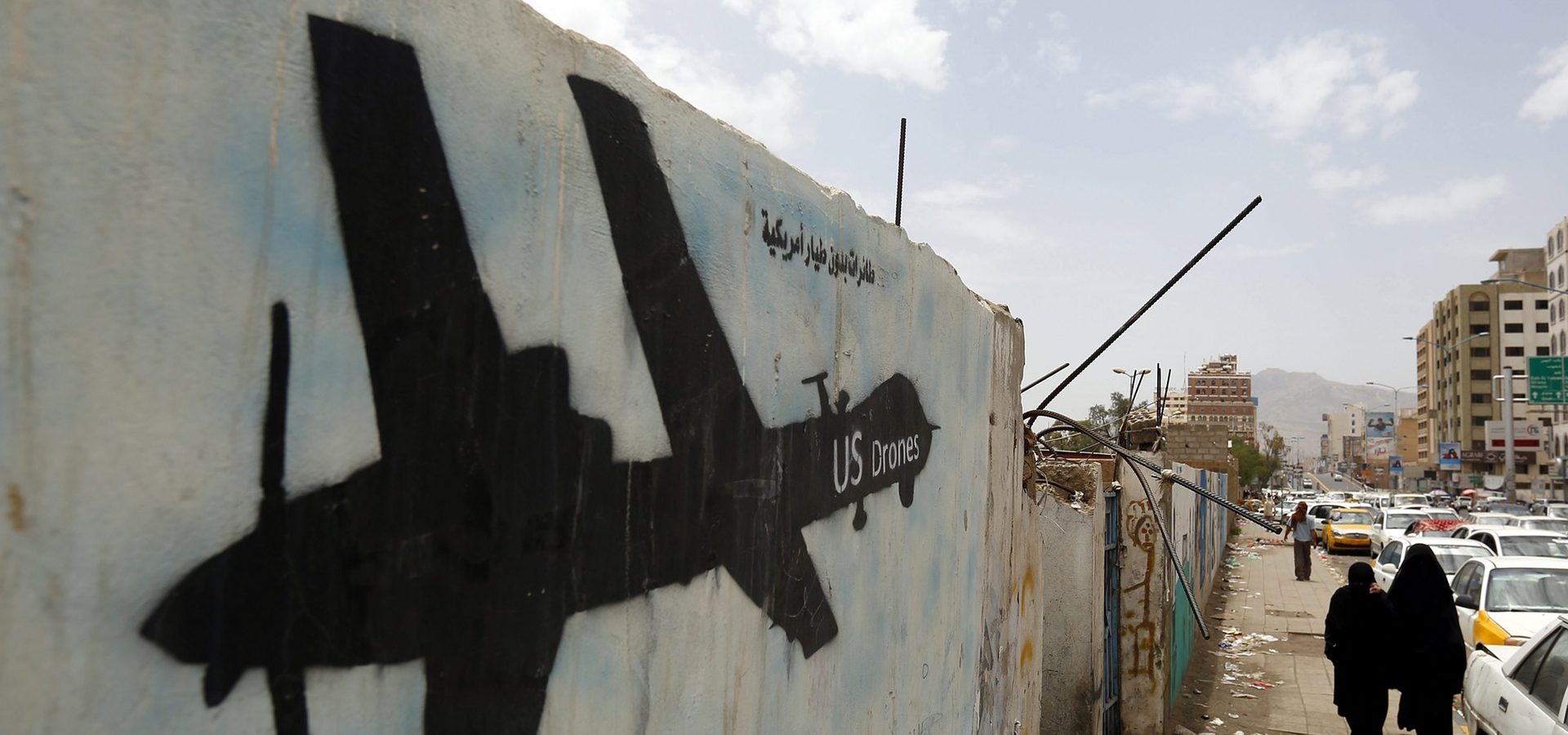Yemenis walk past graffiti showing a US drone. Photograph: Yahya Arhab/EPA