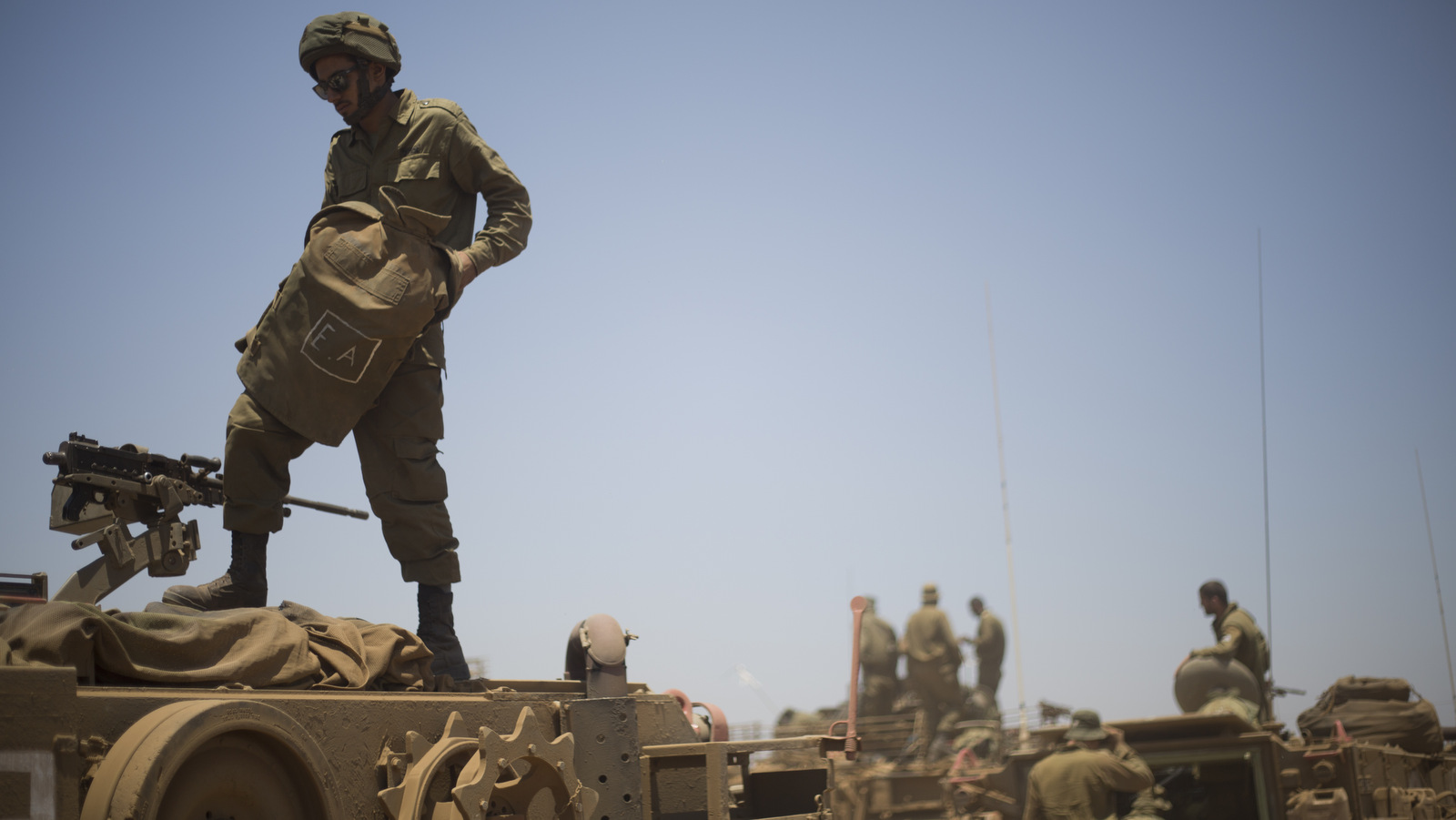 Israeli soldiers stand on top of armored military vehicles during training exercises in the Israeli-occupied Golan Heights, near the border with Syria, Wednesday, June 17, 2015. Syrian rebels launched a wide-ranging offensive against Syrian government positions near the Golan Heights on Wednesday, after tit-for-tat shelling in and around Damascus left at least 33 people dead, activists said. Insurgents have been on the offensive in southern Syria for the past three months, capturing military bases, villages and a border crossing point with Jordan. (AP Photo/Ariel Schalit)